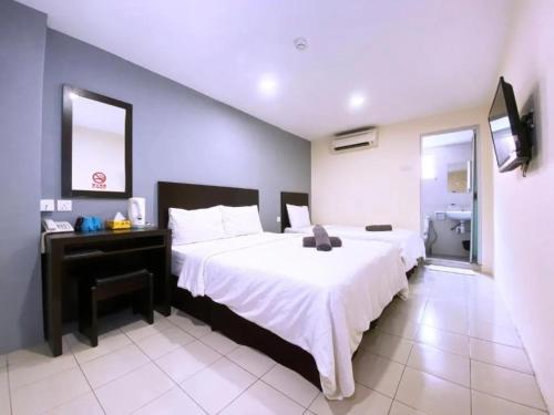 a bedroom with a large white bed and a television at Seeds Hotel Klang Meru in Klang