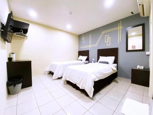 a hospital room with two beds and a tv at Seeds Hotel Klang Meru in Klang