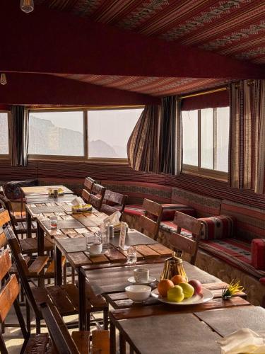 a dining room with wooden tables and chairs and windows at Dana Trail Hotel in Dana