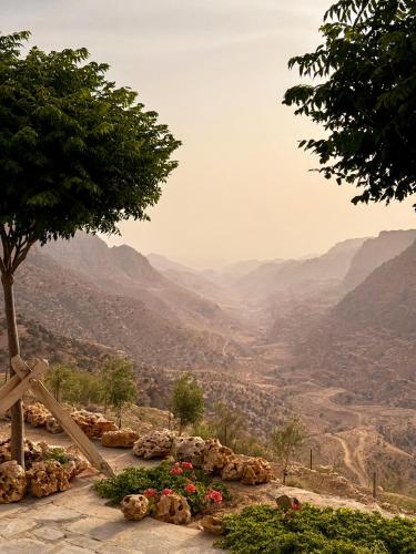 a view of a mountain valley with a tree and flowers at Dana Trail Hotel in Dana