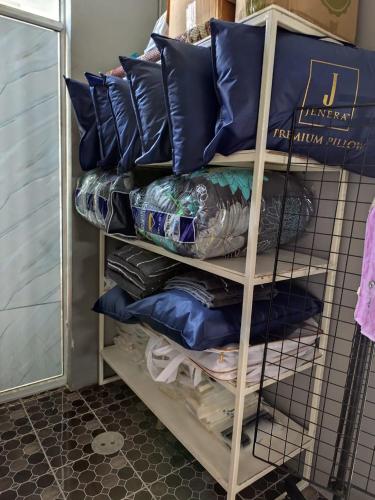 a stack of pillows on a shelf in a room at Narathiwat homestay rumah kelabu in Ban Kam Pong Ba Ru