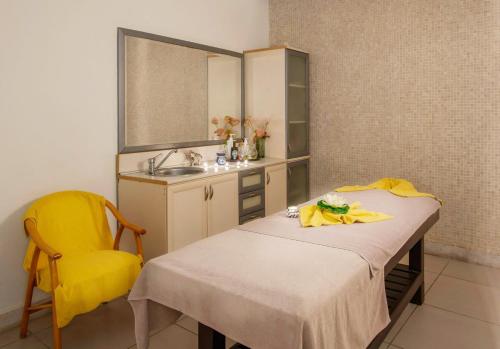a kitchen with a table and a yellow chair at Golden Lotus Hotel in Kemer