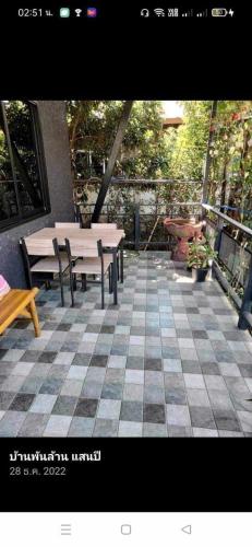 een terras met tafels en banken op een geblokte vloer bij บ้านสโนว์เขาค้อ in Ban Chek