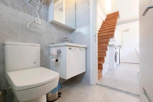 ウルラにあるUrla Surf House Dublex Rooftop Terrace Two Bedroomsのバスルーム(白いトイレ、階段付)