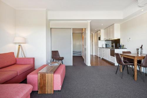 a living room with a couch and a table at Seashells Mandurah in Mandurah