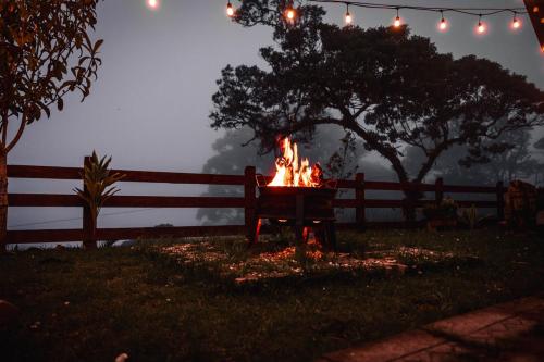 a fire pit in a yard in front of a fence at Loft con hermosas vistas y Volcán Turrialba in Turrialba