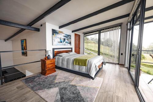 a bedroom with a bed and a large window at Loft con hermosas vistas y Volcán Turrialba in Turrialba