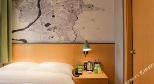 a bedroom with a bed with a map on the wall at Vatica Hotel Hefei Yaohai Longgang Subway Station in Hefei