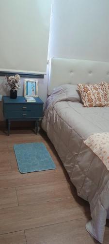 a bedroom with a bed and a table with a night stand at El Contenedor in Tunuyán
