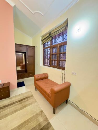 a living room with a couch and a window at Atreya Boutique Cottage Serene Villa Near Ram Jhula in Rishīkesh