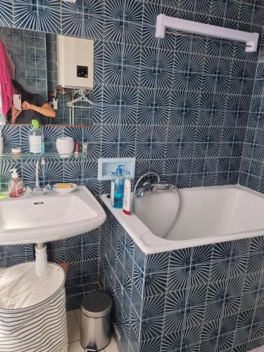 une salle de bain avec un lavabo et une baignoire dans l'établissement Comfy studio, à Paris