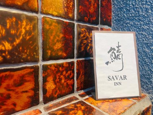a sign on a wall next to a tile wall at SAVAR inn - Onomichi in Onomichi