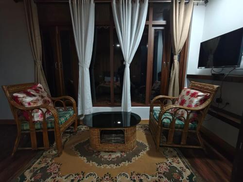 a living room with two chairs and a table at Lenzila Retreat in Ravangla