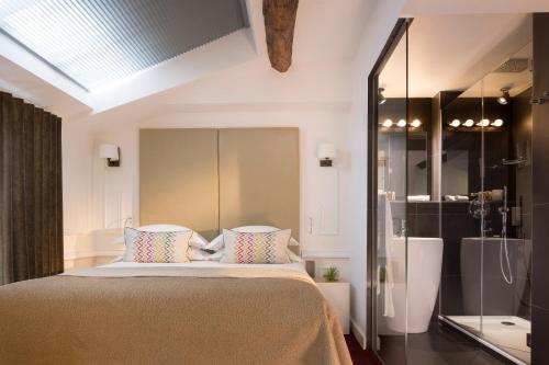 a bedroom with a large bed and a shower at Hôtel Molière in Paris