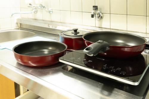 two pots and pans sitting on a stove in a kitchen at Mary's Maison Repos in Fukuoka