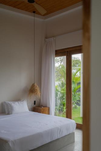 a bedroom with a bed and a large window at Naiya Villa in Piyadigama