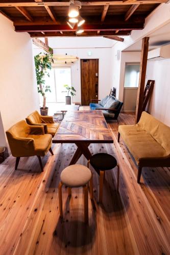 a living room with a table and chairs at CHILLHOUSE 一棟貸し宿kumanokodo in Nachikatsuura