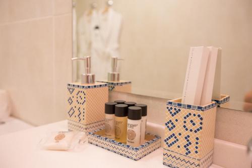 a bathroom counter with three containers of cosmetics on it at President Hotel in Ufa