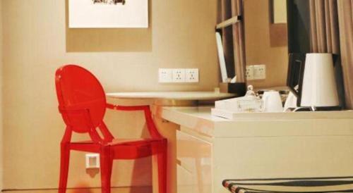 a red chair sitting at a desk in a room at Jinjiang Metropolo Hotel Classiq Shanghai Off Bund in Shanghai