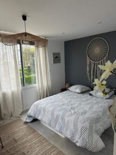 une chambre avec un lit et une grande fenêtre dans l'établissement la Villa des Cigales, à Coudeville-sur-Mer