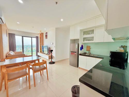 a kitchen and living room with a table and chairs at Châu Giang Homestay, Nera Garden Huế in Thôn Văn Dương