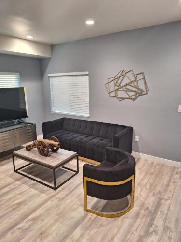 a living room with a black couch and a coffee table at My amazing home in Azusa