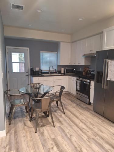 a kitchen with a glass table and chairs in a kitchen at My amazing home in Azusa