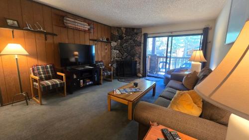 a living room with a couch and a television at Eagle Summit Collection in Mammoth Lakes