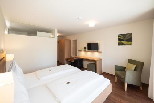 a hotel room with a bed and a chair at Gästehaus GN8 in Rielasingen-Worblingen