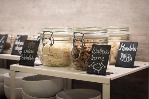 a shelf with jars of food on it with signs at Gästehaus GN8 in Rielasingen-Worblingen