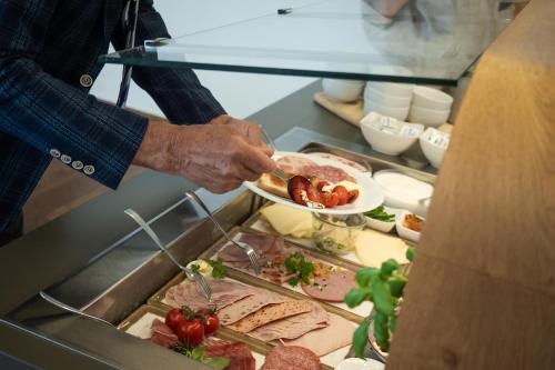a person holding a plate of food in a buffet at Gästehaus GN8 in Rielasingen-Worblingen