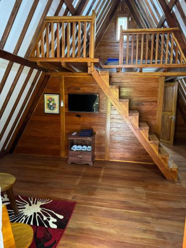 an attic room with a staircase in a cabin at Curug Goong Resort in Subang