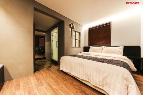 a bedroom with a large bed and a window at Yeongdeungpo Station New York Hotel in Seoul