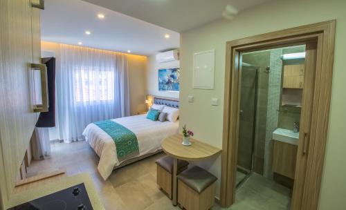 a bedroom with a bed and a bathroom with a shower at Zodiac Hotel Apartments in Larnaka