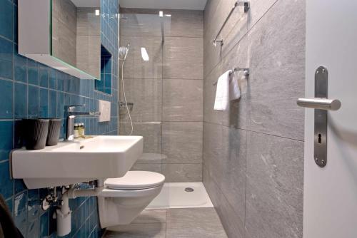 a bathroom with a white sink and a toilet at BANK House Studio L 205 - GRIWA RENT in Interlaken