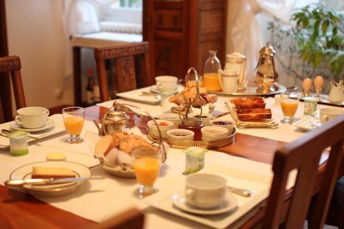 une table avec des aliments pour le petit-déjeuner et du jus d'orange dessus dans l'établissement Chateau-Gaillard, à Corbelin