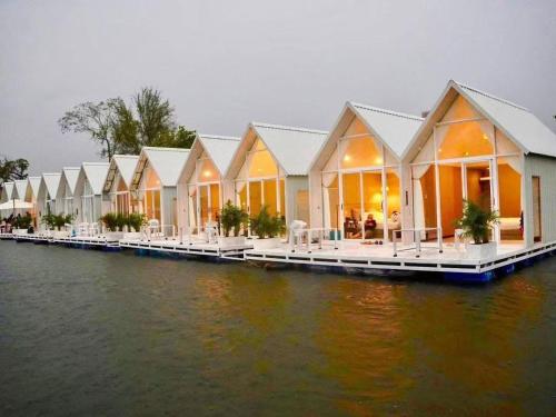 M & R 2 float house في Muang Fuang: صف من المنازل على رصيف على الماء