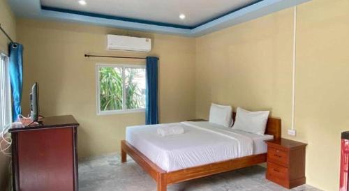 a bedroom with a bed and a tv and a window at Hihotel Saraburi in Sara Buri