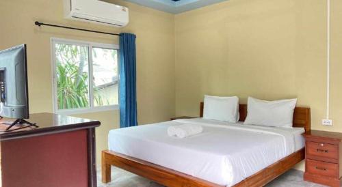 a bedroom with a bed and a tv and a window at Hihotel Saraburi in Sara Buri