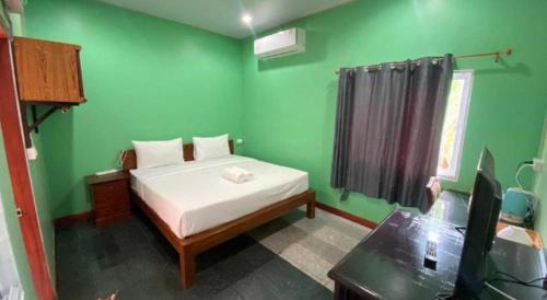 a bedroom with a bed in a green room at Hihotel Saraburi in Sara Buri