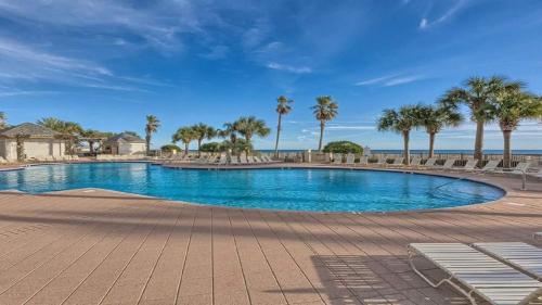 ein großer Swimmingpool mit Palmen und dem Meer in der Unterkunft Beach Club B1701-New Rental- Gorgeous Corner unit in Gulf Shores