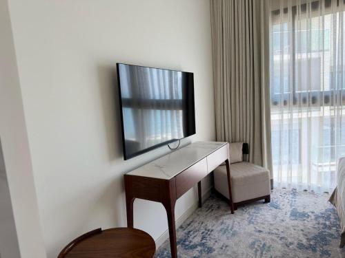 a hotel room with a television on a desk at Address Beach Resort Fujairah Apartment by Blue World - 5 in Fujairah