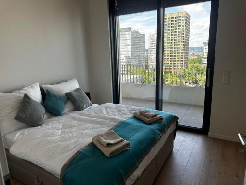 a bedroom with a large bed with towels on it at Fancy Apartment with amazing Sky View in Nivy