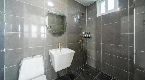 a bathroom with a sink and a urinal and a mirror at Gallery Pension in Taean