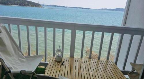 a balcony with a table and a chair and the ocean at Gallery Pension in Taean