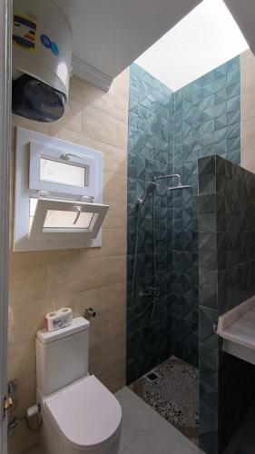 a bathroom with a shower and a toilet and a sink at Sea sky sleep & repeat in Dawwār ‘Abd Allāh