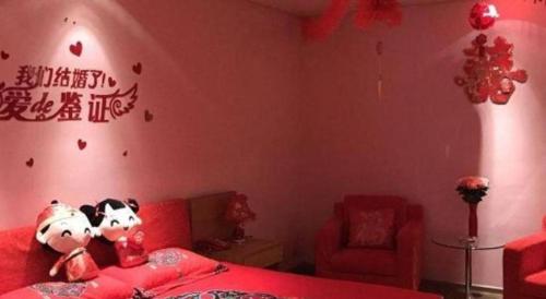 a bedroom with two hello kitty stuffed animals on a bed at Tangshan Qiangang Hotel in Qian'an