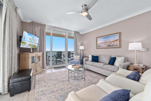 ein Wohnzimmer mit Sofa und Tisch in der Unterkunft Beach Club B1701-New Rental- Gorgeous Corner unit in Gulf Shores