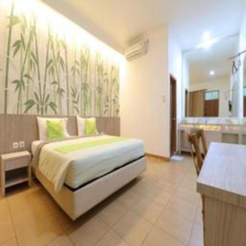 a bedroom with a bed in a room with a kitchen at Hotel Huswah Airport in Jakarta