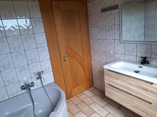 a bathroom with a white tub and a sink at Les hauts du Schliffels in Fellering